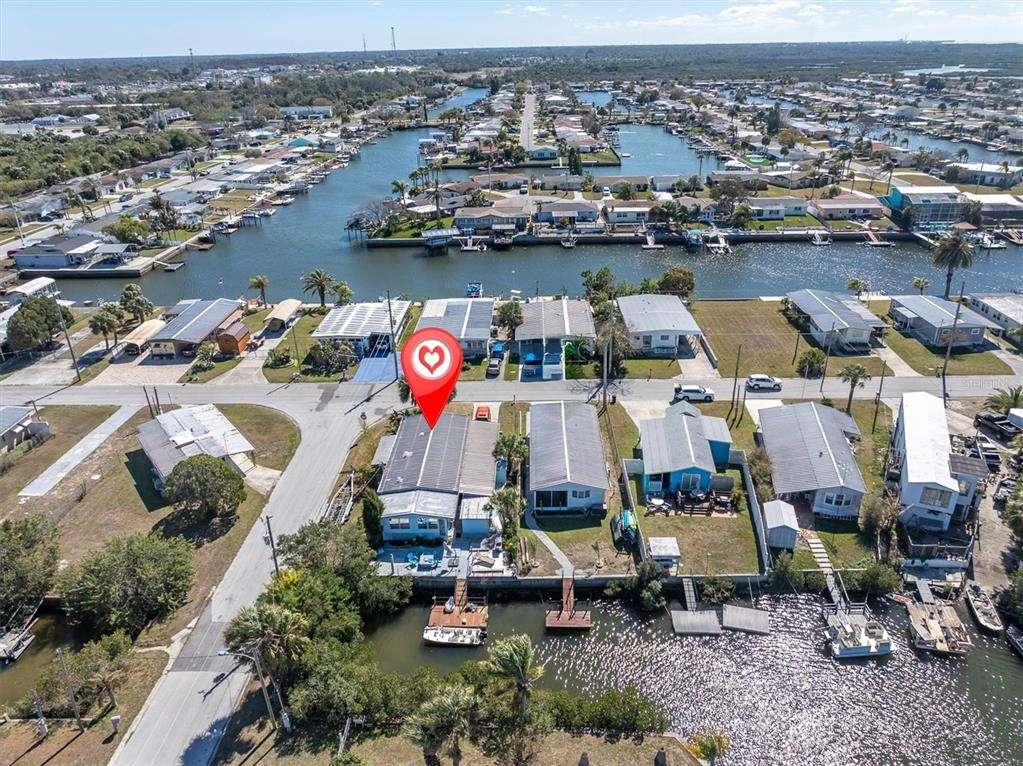 An aerial view shows a waterfront mobile home community with a marked property and docks — 6629 TOWER DRIVE, HUDSON, FL