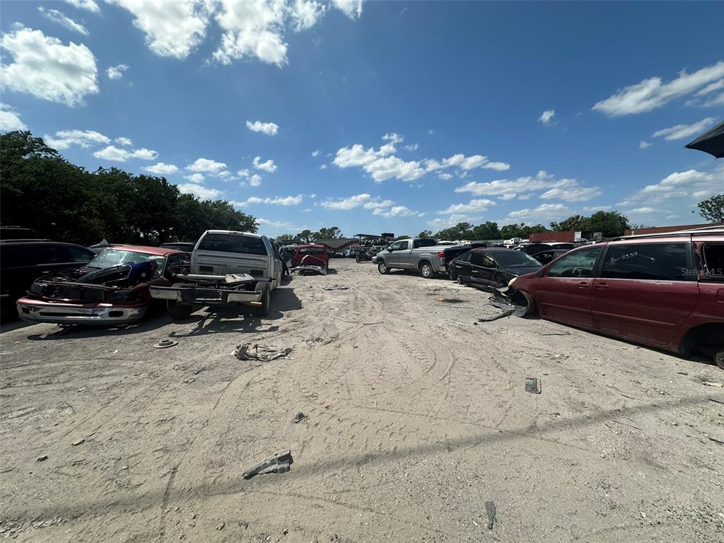 A dirt lot filled with various wrecked and salvaged vehicles under a blue sky — 8020 S 78TH STREET, RIVERVIEW, FL