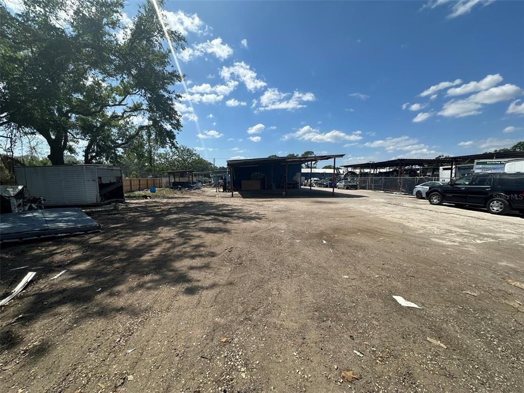 A large, unpaved dirt lot features a metal storage structure and several parked vehicles — 8020 S 78TH STREET, RIVERVIEW, FL