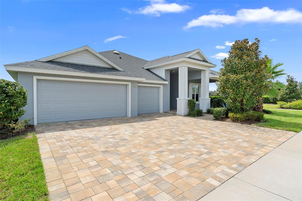 A single-story house with a gray exterior, a paved driveway, and a two-car garage — 1548 LAKE RESERVE DRIVE, DELAND, FL