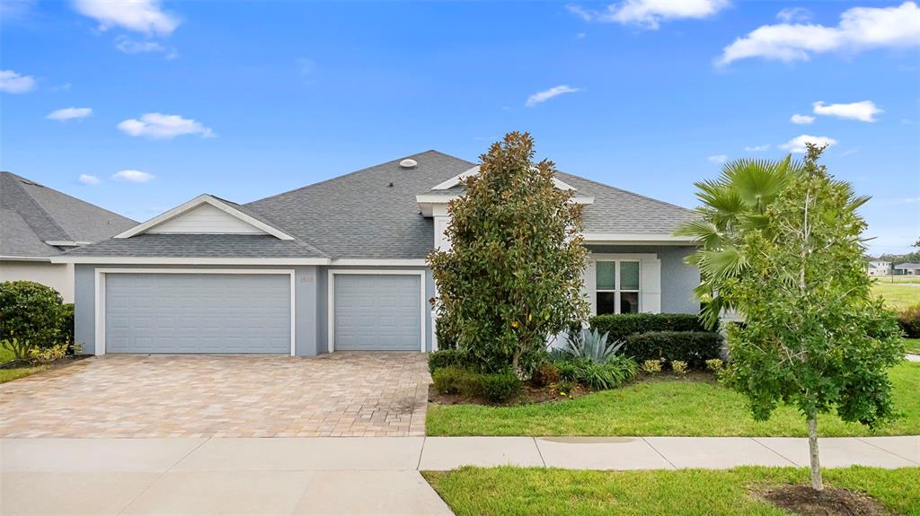 A single-story house with a gray exterior, a paved driveway, and a manicured front lawn — 1548 LAKE RESERVE DRIVE, DELAND, FL