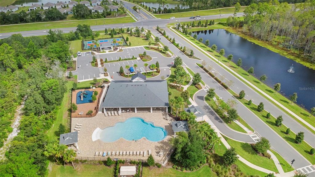 An aerial view shows a community clubhouse with a swimming pool, playground, and tennis courts — 1548 LAKE RESERVE DRIVE, DELAND, FL