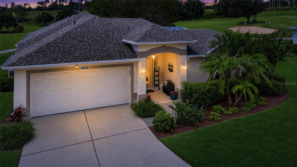 An exterior view of a single-story house with a garage and a golf course view — 1940 FARMINGTON COURT, CLERMONT, FL