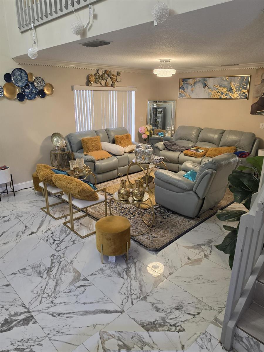 A living room features gray leather sofas, gold accent tables, and marble-patterned tile flooring — 5351 NW 41st Way, Coconut Creek FL 33073, COCONUT CREEK, FL