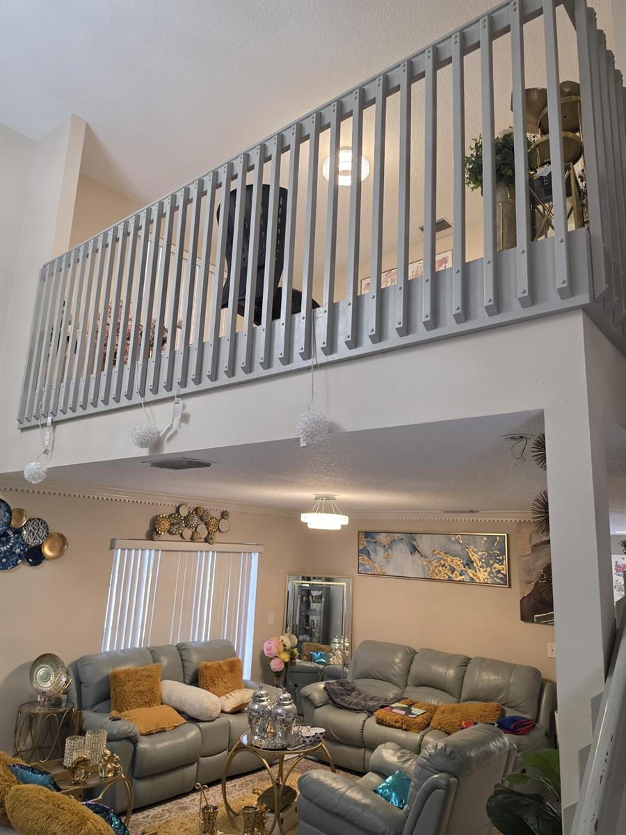 A living room with a high ceiling, a gray loft railing, and gray leather furniture — 5351 NW 41st Way, Coconut Creek FL 33073, COCONUT CREEK, FL