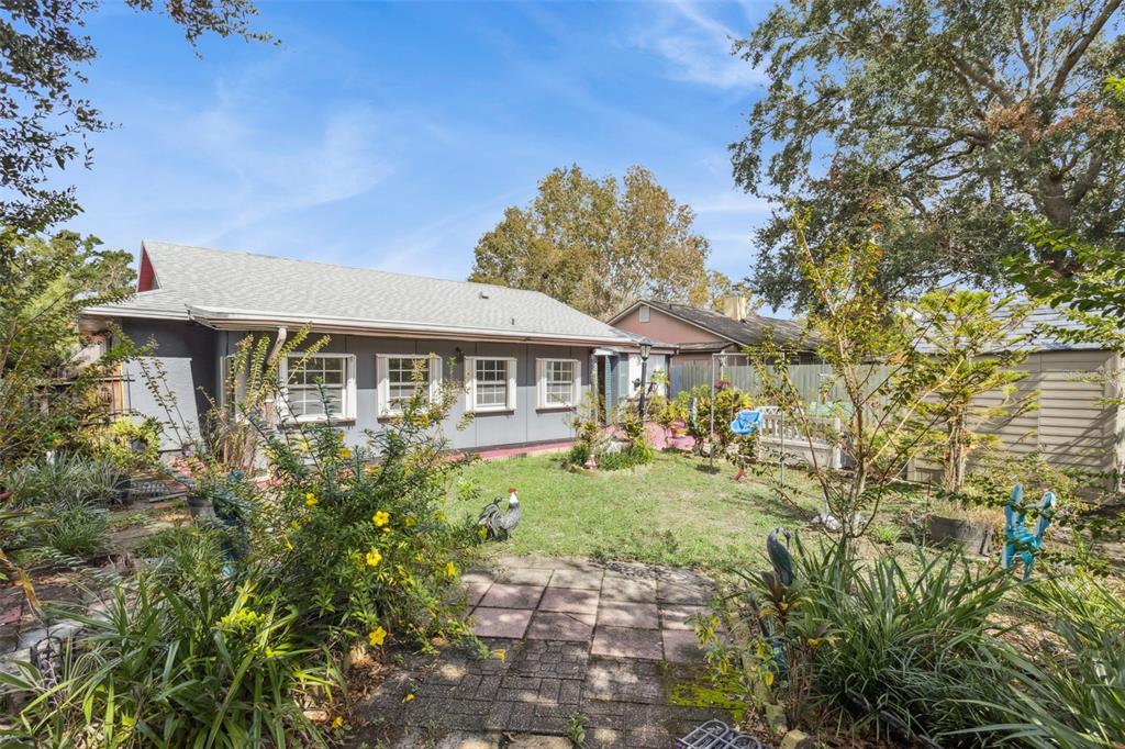 A backyard view of a gray house with a patio and a small lawn — 3646 FALLING LEAF LANE, ORLANDO, FL