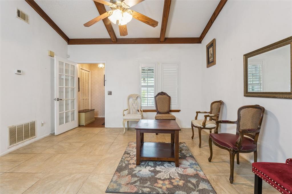 A living room features tile flooring, exposed wooden ceiling beams, and several antique-style chairs — 3646 FALLING LEAF LANE, ORLANDO, FL