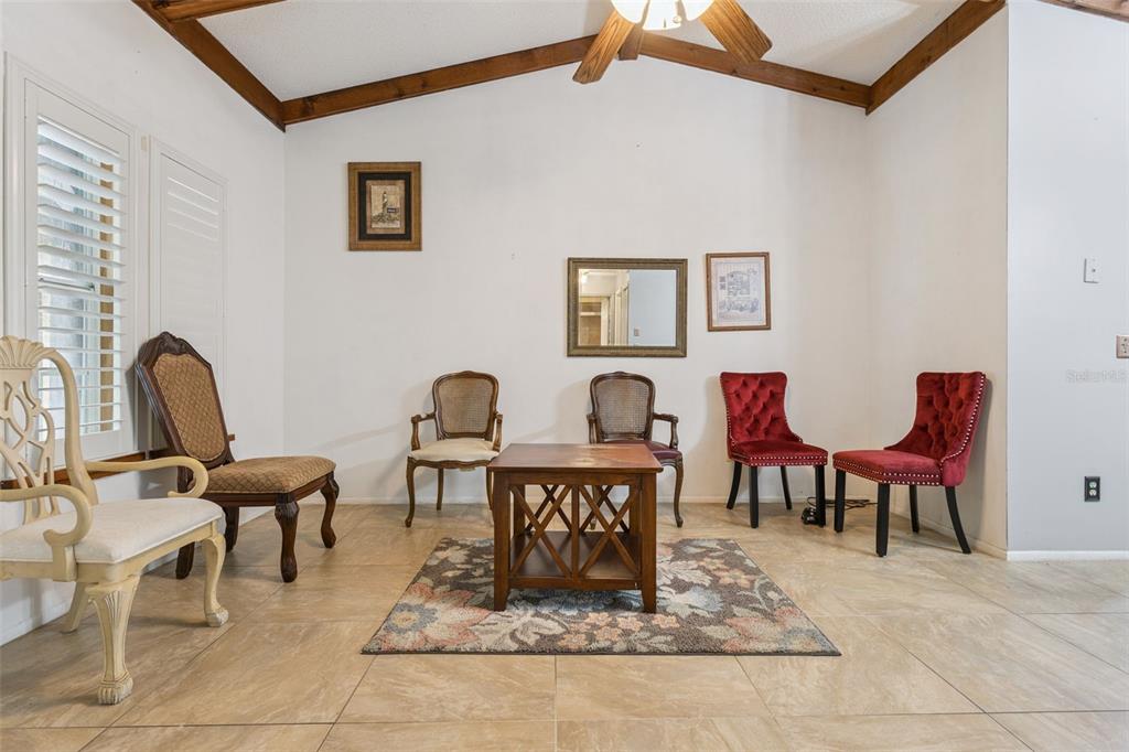A living room features vaulted ceilings with exposed beams, tile flooring, and several assorted chairs — 3646 FALLING LEAF LANE, ORLANDO, FL