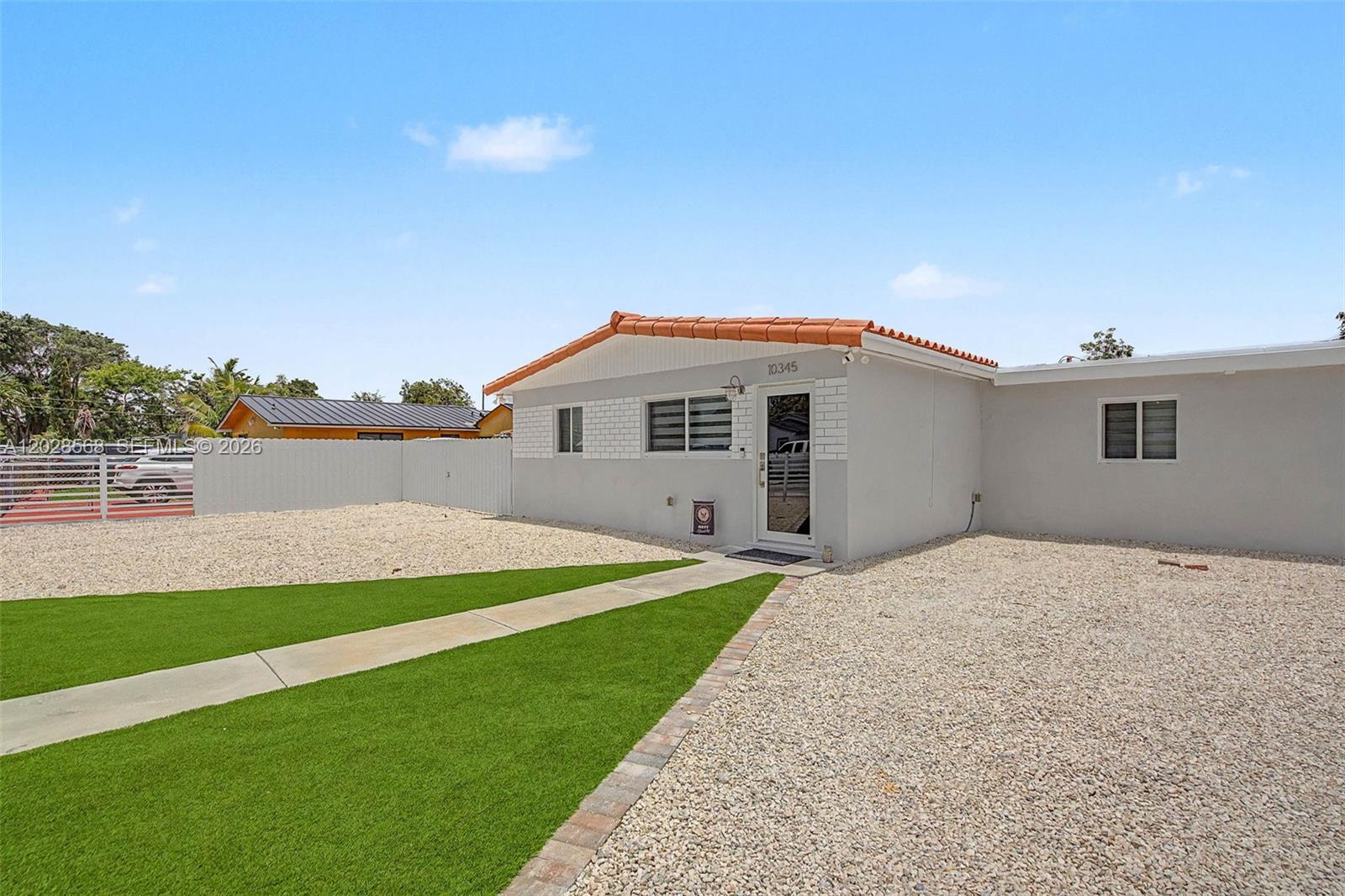A single-story house with a gravel yard, artificial turf, and a tiled roof — 10345 NW 35th Ct, Miami FL 33147, MIAMI, FL