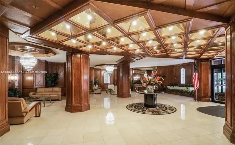 A spacious lobby features wood-paneled walls, a coffered ceiling with recessed lighting, and tile flooring — 1865 S Ocean Dr # 12L, Hallandale Beach FL 33009, HALLANDALE BEACH, FL