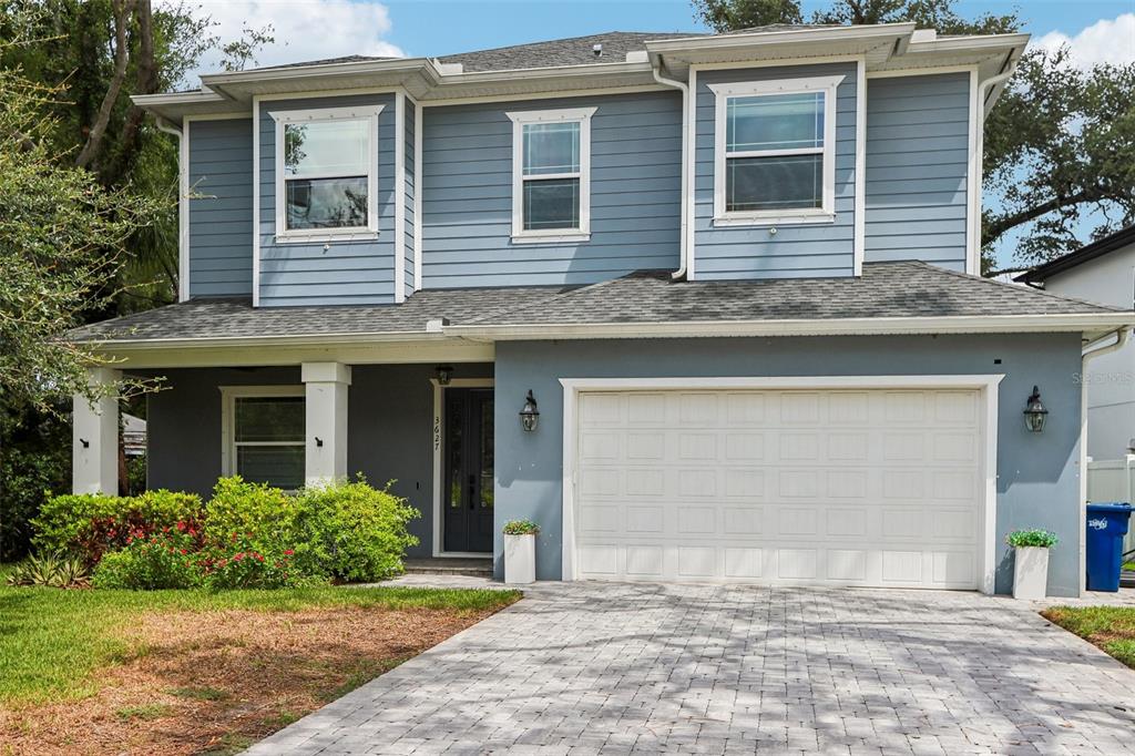 A two-story house with blue siding, a white garage door, and a paved driveway — 3627 E CLARK CIRCLE, TAMPA, FL