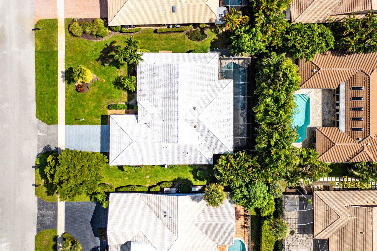 An aerial view shows a residential house with a white roof, pool enclosure, and landscaping — 4572 White Cedar Lane, Delray Beach FL 33445, DELRAY BEACH, FL