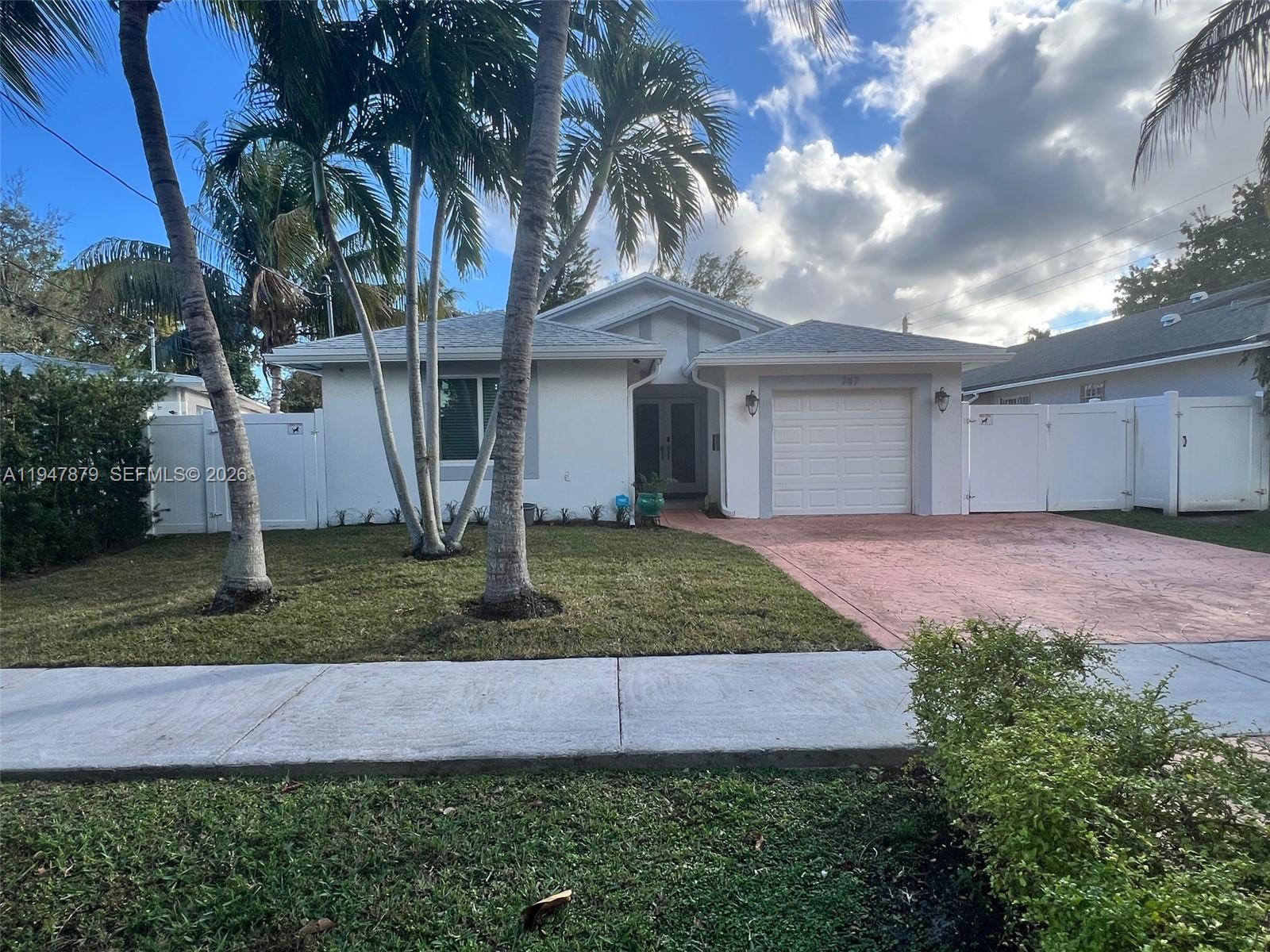 A single-story house with a white exterior, a one-car garage, and palm trees in front — 747 SW 6th St, Hallandale Beach FL 33009, HALLANDALE BEACH, FL