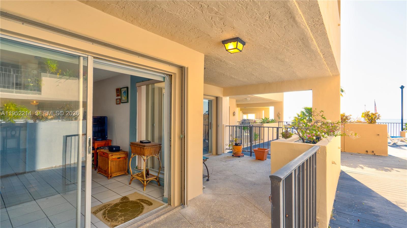 A balcony with a concrete floor and metal railing overlooks a deck and ocean — 79901 Overseas Higway # 204, Islamorada FL 33036, ISLAMORADA, FL