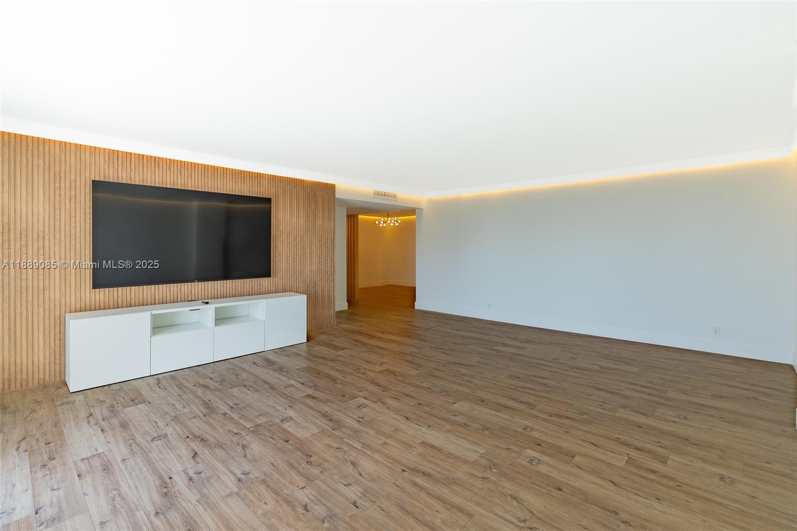 A living room features a wood-slatted accent wall, a white media console, and recessed lighting — 2030 S Ocean Dr # 1127, Hallandale Beach FL 33009, HALLANDALE BEACH, FL