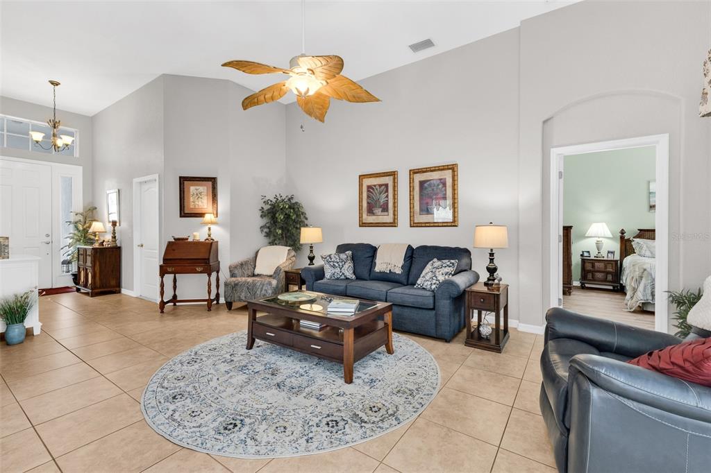 A living room features tile floors, a blue sofa, a coffee table, and a ceiling fan — 1725 PICCADILLY CIRCLE, PUNTA GORDA, FL