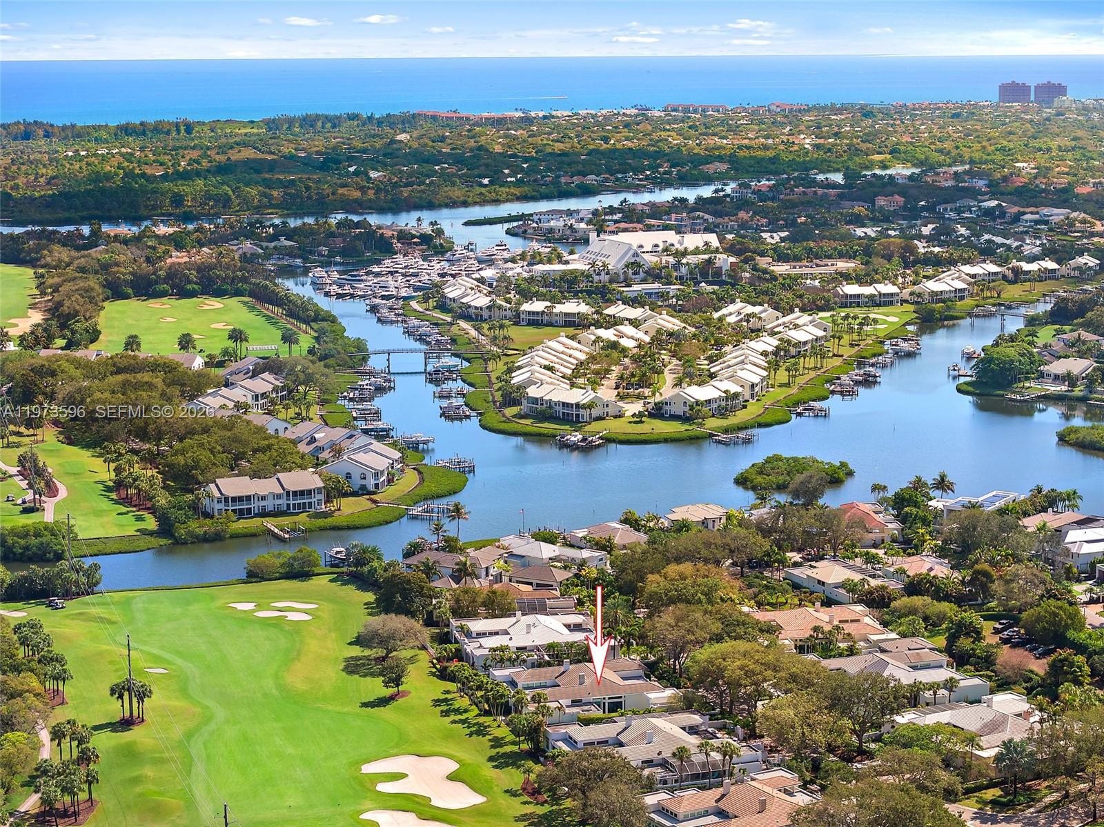 An aerial view shows a residential community with golf course fairways and a waterway — 108 Waters Edge Dr, Jupiter FL 33477, JUPITER, FL