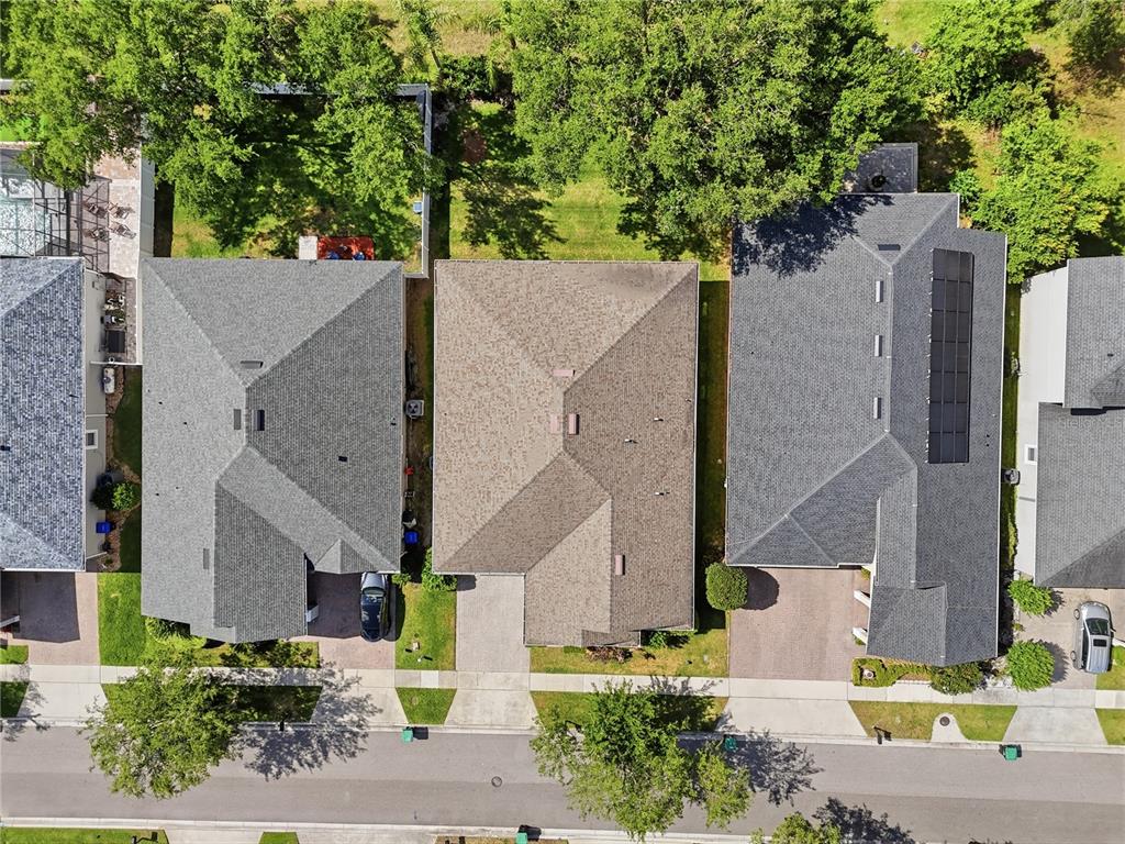 An aerial view shows three suburban houses with shingled roofs and driveways along a street — 13226 ZORI LANE, WINDERMERE, FL