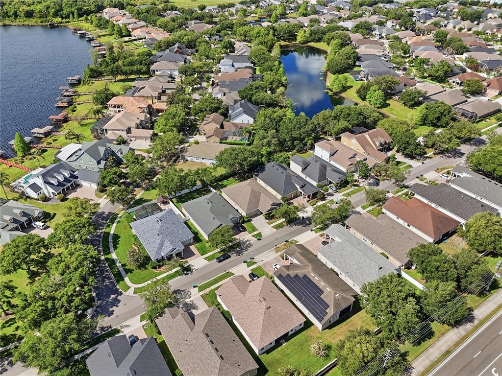An aerial view shows a suburban neighborhood with houses, a lake, and a pond — 13226 ZORI LANE, WINDERMERE, FL