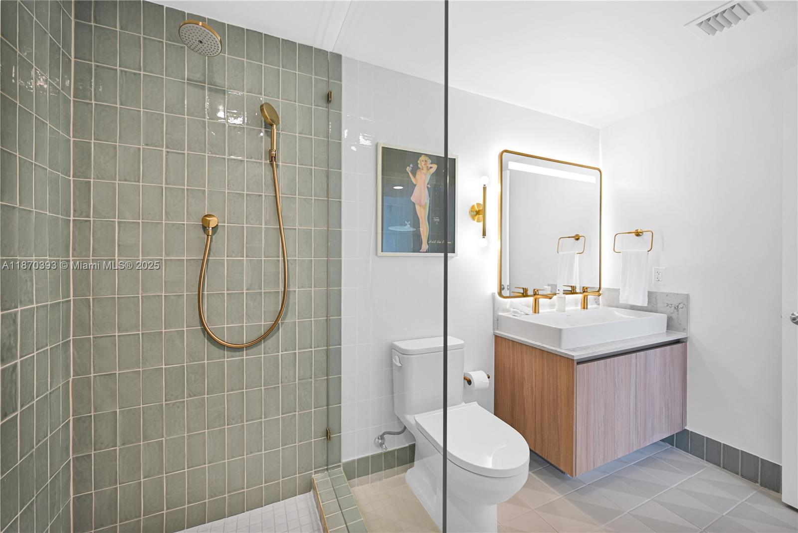 A bathroom features a glass-enclosed shower with sage green tiles and gold fixtures — 159 NE 6th St # 3901, Miami FL 33132, MIAMI, FL