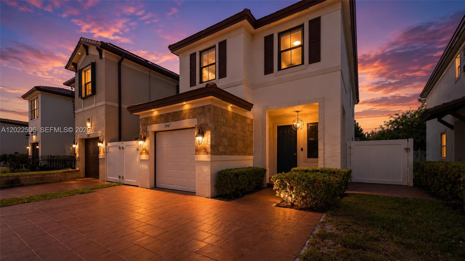 A two-story house with a stone-accented garage and paved driveway at sunset — 3567 W 110th Ter, Hialeah FL 33018, HIALEAH, FL