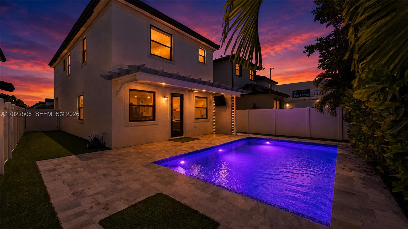 A two-story house exterior features a backyard pool with purple lighting and a patio — 3567 W 110th Ter, Hialeah FL 33018, HIALEAH, FL