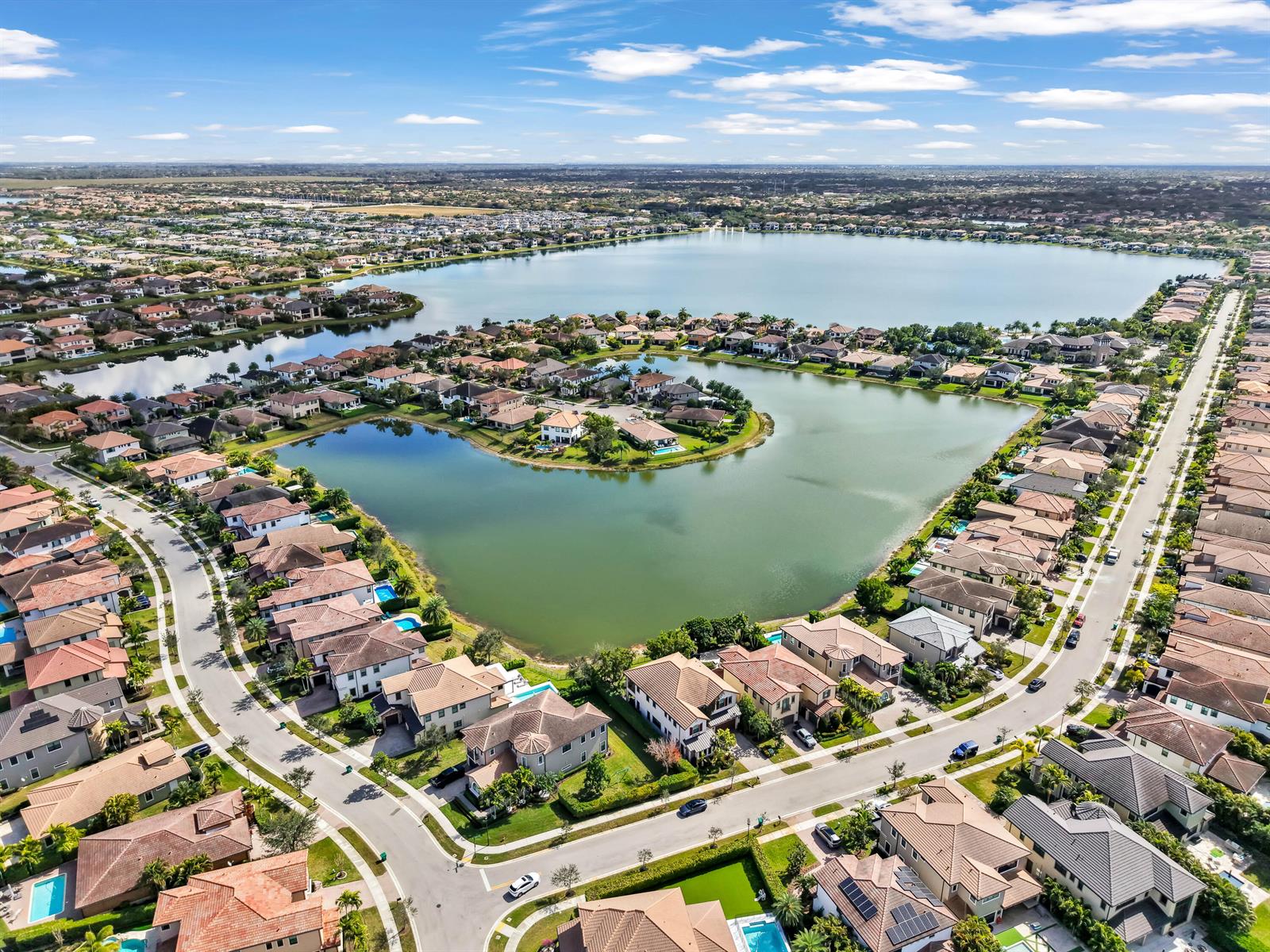 An aerial view of a suburban neighborhood surrounding a large lake with numerous houses — 9040 W Watercrest Cir Circle W, Parkland FL 33076, PARKLAND, FL