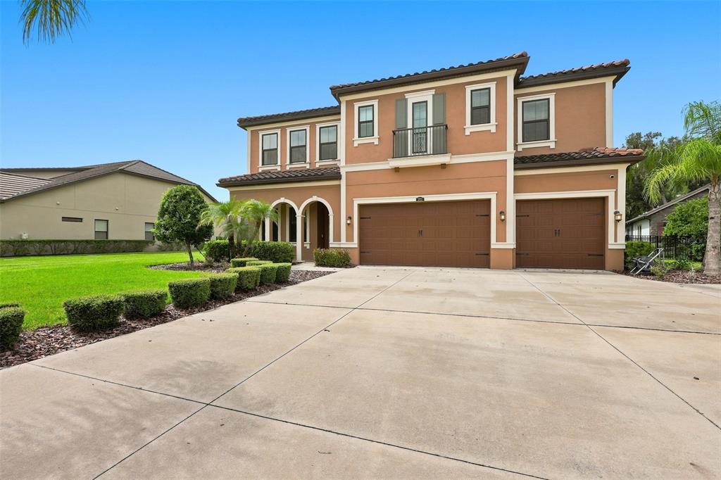 A two-story stucco house features a three-car garage and a concrete driveway — 3225 CORDOBA RANCH BOULEVARD, LUTZ, FL