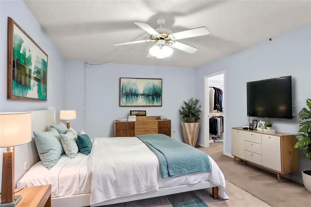 A bedroom features a bed, a dresser, a television, and a ceiling fan — 1810 VILLAGE CT, MULBERRY, FL