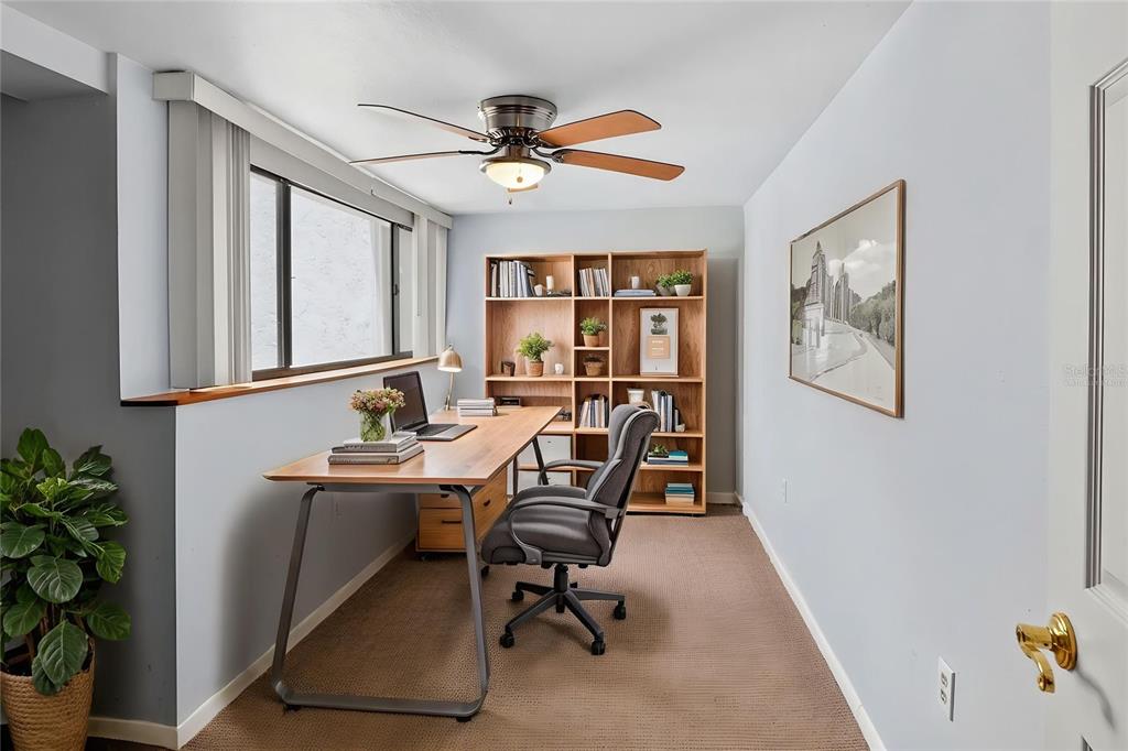 A home office with a wooden desk, bookshelf, gray office chair, and a ceiling fan — 1810 VILLAGE CT, MULBERRY, FL
