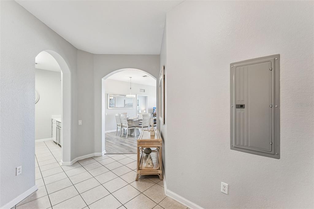 A tiled hallway leads to a dining area through an arched opening with a breaker panel — 4862 CAYVIEW AVENUE UNIT 403, ORLANDO, FL