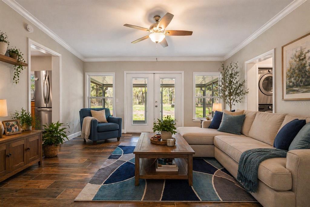 A living room features a sectional sofa, blue armchair, wood coffee table, and tile flooring — 10928 W FORT ISLAND TRAIL, CRYSTAL RIVER, FL