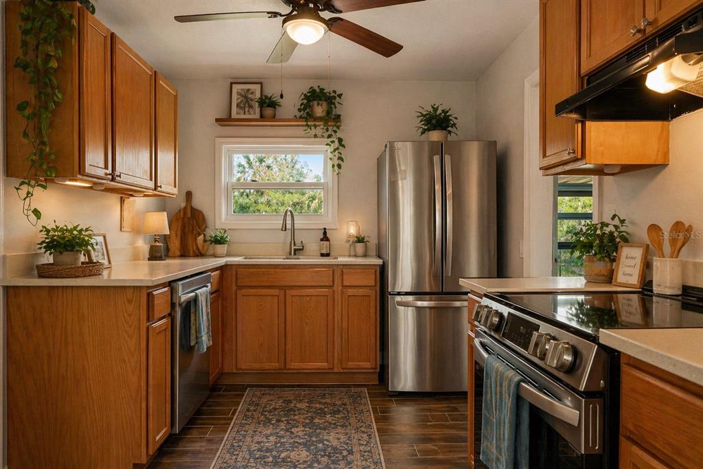 A kitchen with wood cabinets, stainless steel appliances, a window above the sink, and plants — 10928 W FORT ISLAND TRAIL, CRYSTAL RIVER, FL