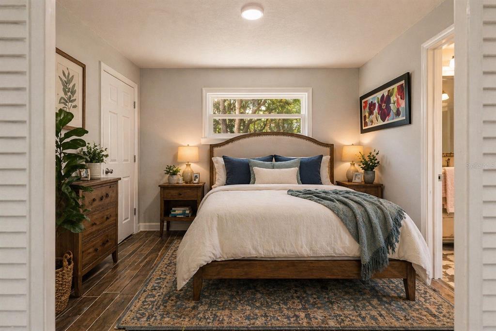 A bedroom features a queen bed, wooden furniture, a window, and a patterned area rug — 10928 W FORT ISLAND TRAIL, CRYSTAL RIVER, FL