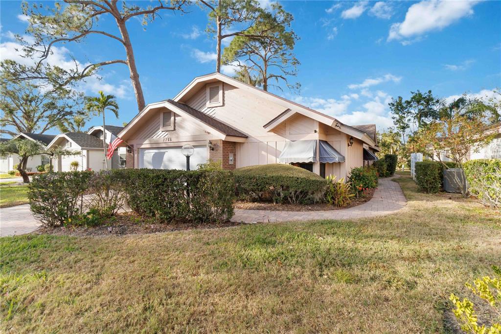 A single-story house with light-colored siding, a garage, and a paved walkway in front — 7755 PINE TRACE DRIVE UNIT 7755, SARASOTA, FL