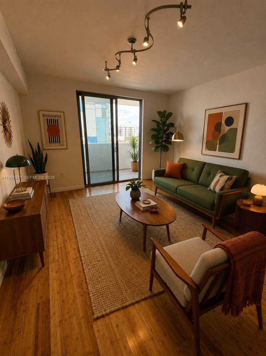 A living room features a green sofa, wooden furniture, a jute rug, and balcony access — 36 NW 6th Ave # 504, Miami FL 33128, MIAMI, FL