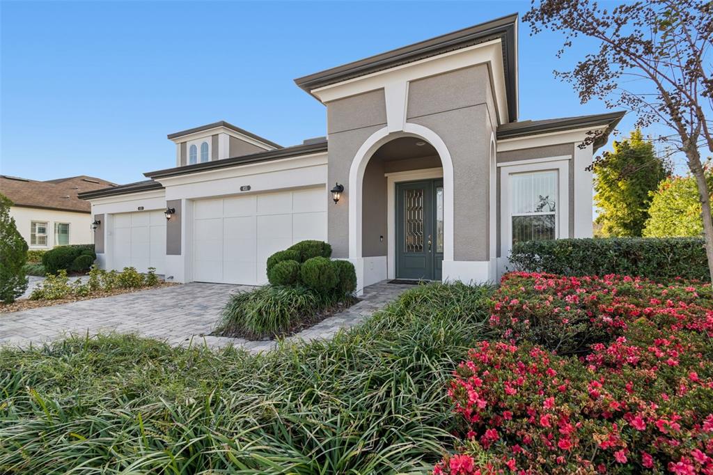 A single-story house with a paved driveway, white garage door, and arched entryway — 4155 BARLETTA COURT, WESLEY CHAPEL, FL