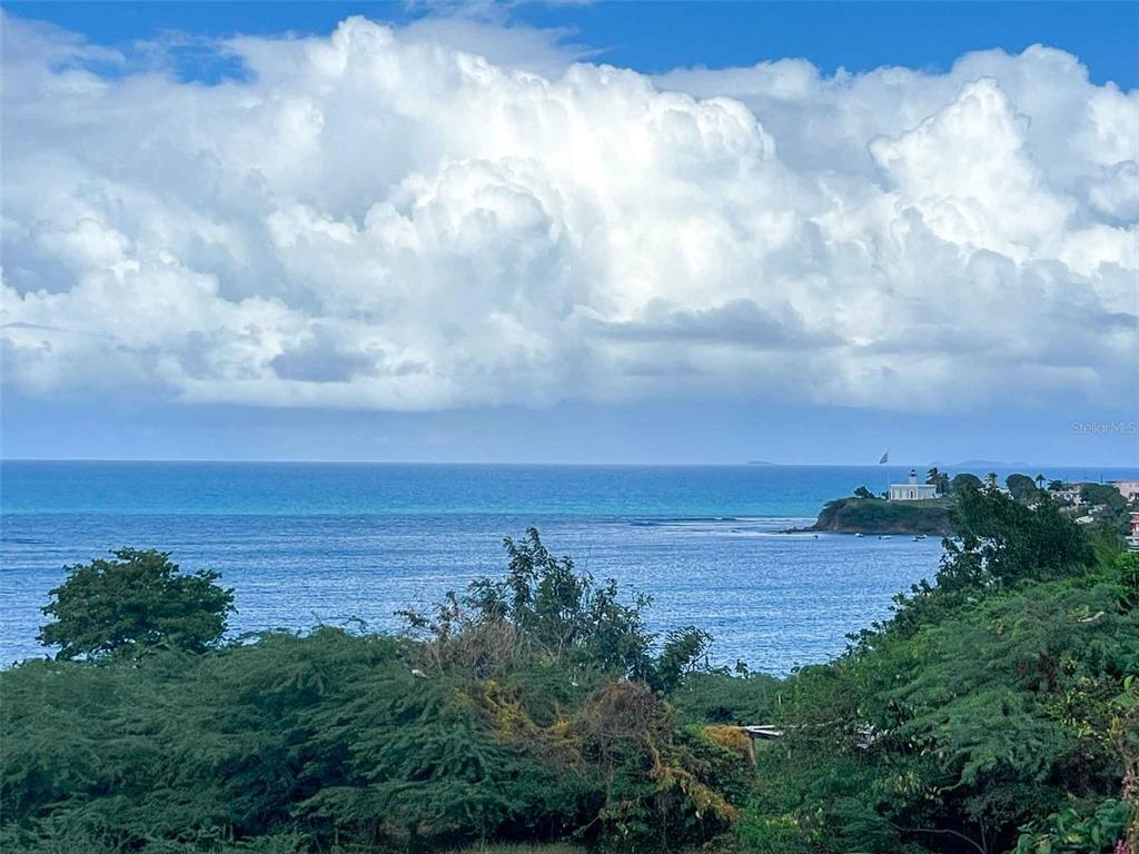 A view of the ocean and coastline with a lighthouse in the distance — 53 CALLE CANON, VIEQUES, PR