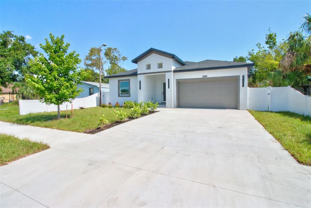 A single-story white house with a gray garage door and a concrete driveway — 6127 105TH TERRACE, PINELLAS PARK, FL