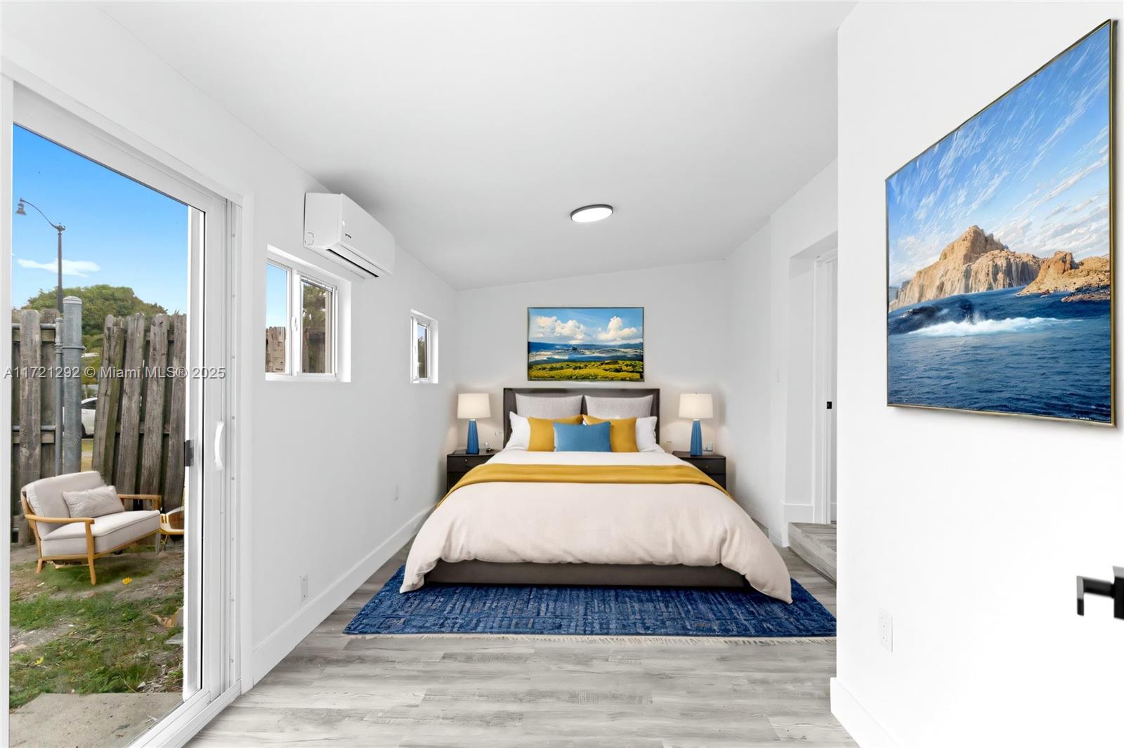 A bedroom features a bed, a blue rug, a sliding glass door, and an exterior patio — 1560 NE 42nd Ct, Pompano Beach FL 33064, POMPANO BEACH, FL