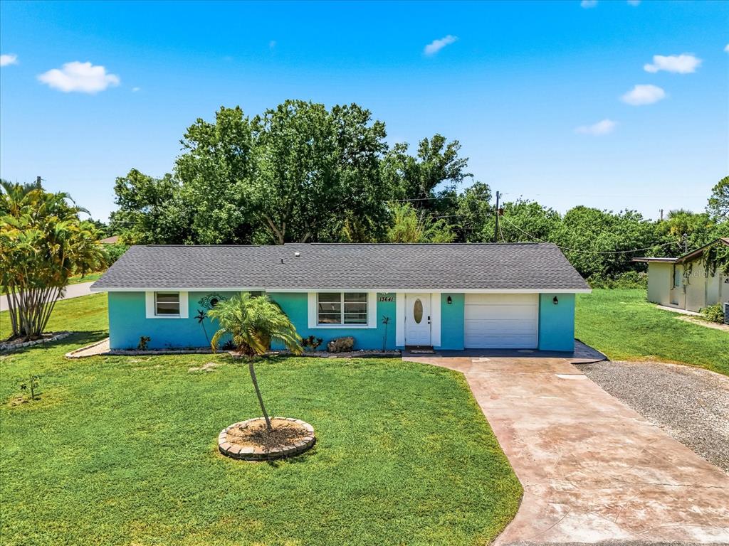 A single-story house with a teal exterior, a white garage door, and a front lawn — 13641 DRYSDALE AVENUE, PORT CHARLOTTE, FL