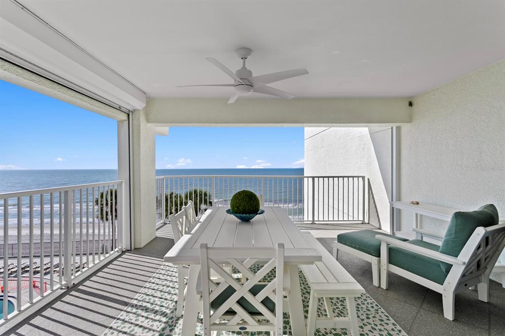 A covered balcony features a white dining set, a lounge chair, and ocean views — 16332 GULF BOULEVARD UNIT 3B, REDINGTON BEACH, FL