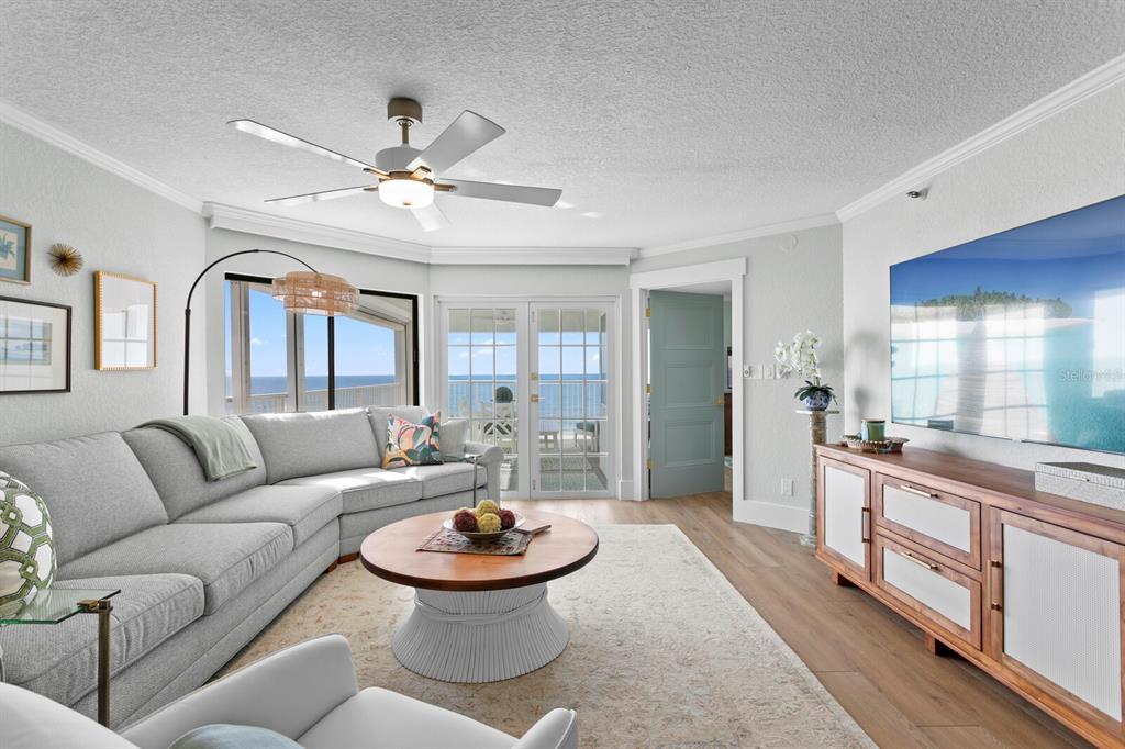 A living room features a gray sectional sofa, a round coffee table, and ocean views — 16332 GULF BOULEVARD UNIT 3B, REDINGTON BEACH, FL