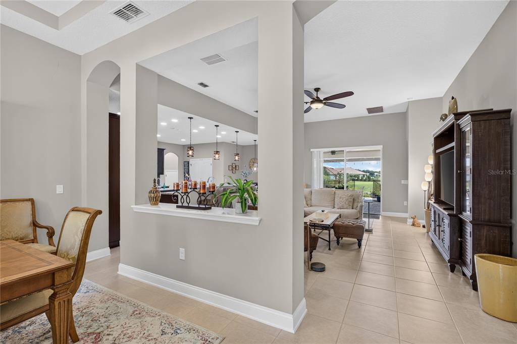 A view from a dining area looking into a living room and kitchen with tile floors — 31948 GEOFF WAY, SORRENTO, FL