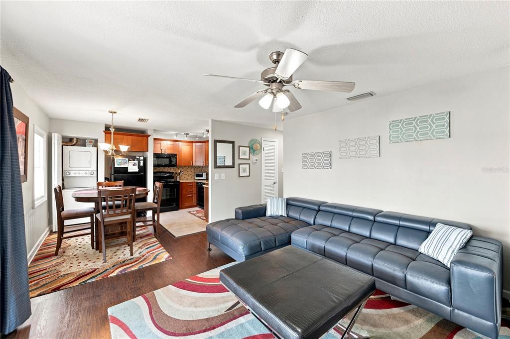 A living room with a sectional sofa and dining area adjacent to a kitchen — 5191 SALMON DRIVE SE UNIT D, ST PETERSBURG, FL