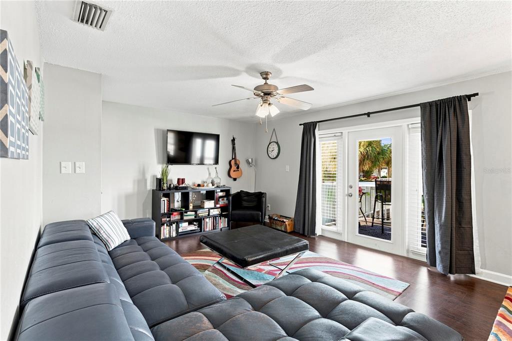 A living room features a large gray sectional sofa, a black ottoman, and a glass door — 5191 SALMON DRIVE SE UNIT D, ST PETERSBURG, FL