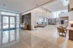 A spacious, modern lobby features polished stone floors, high ceilings, and contemporary seating areas — 6801 Collins Ave, Miami Beach FL 33141, MIAMI BEACH, FL