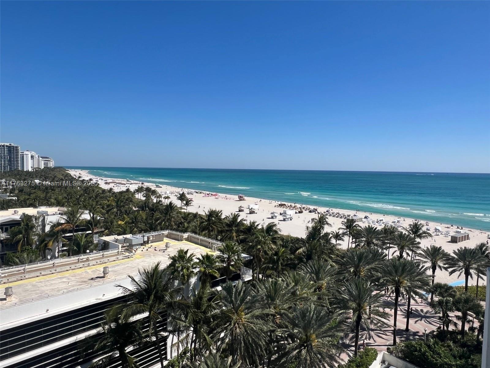An elevated view of a sandy beach, turquoise ocean, and palm trees under a clear sky — 100 Lincoln Rd # 945, Miami Beach FL 33139, MIAMI BEACH, FL