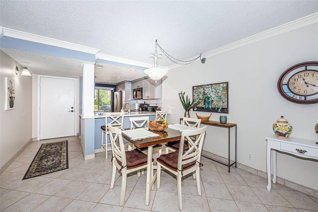 A dining area with a glass-topped table and chairs sits adjacent to a kitchen counter — 6281 BAHIA DEL MAR BOULEVARD UNIT 105, ST PETERSBURG, FL