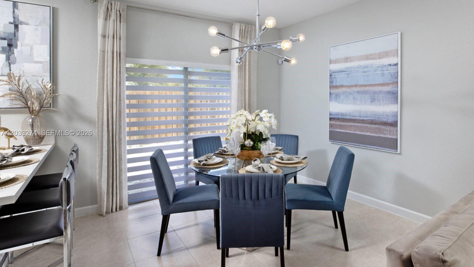 A dining room features a glass table with blue chairs, a chandelier, and sliding doors — 2591 SE 26 CT, Homestead FL 33035, HOMESTEAD, FL